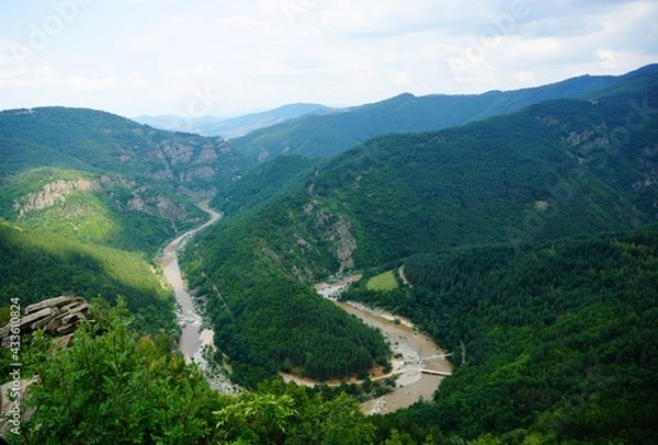 Fototapeta River flowing between mountains