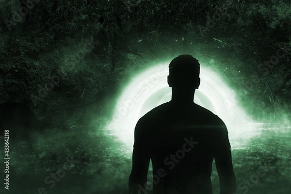Fototapeta image of a person looks through the magic window of the tunnel. the stargate is open teleportation. magic tunnel in the rock portal