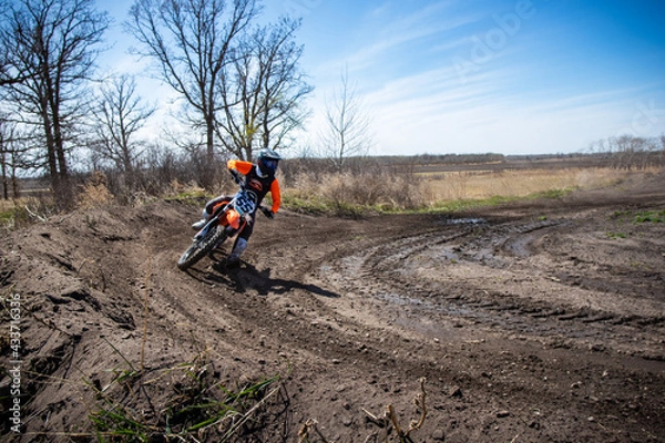 Fototapeta Motocross rider entering a corner.