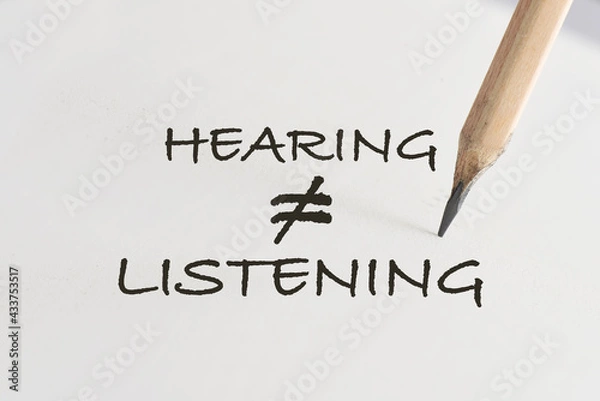 Fototapeta Hearing not equal listening written on white paper with pencil. Communication with understanding concept and soft skill idea