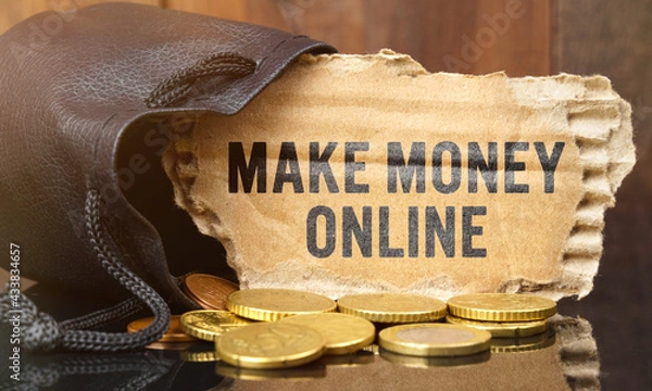 Fototapeta On the table is a bag of money from which sticks out cardboard with the inscription - MAKE MONEY ONLINE