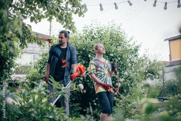 Fototapeta Two men are working in the garden.