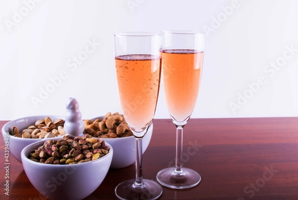 Fototapeta Glass of Pink Sparkling Wine  with Nuts Mixed. .