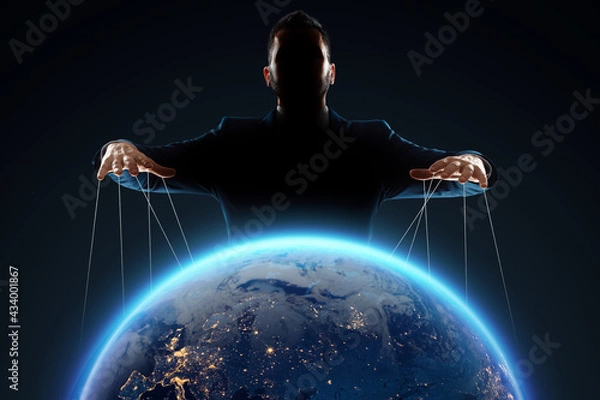 Obraz A man, a puppeteer, manipulates the planet. The concept of world conspiracy, world government, manipulation, world control.