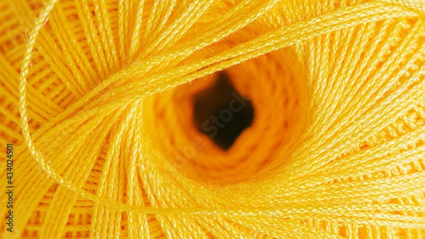 Fototapeta Close-up of a skein of thread. Textured illuminating yellow background.
