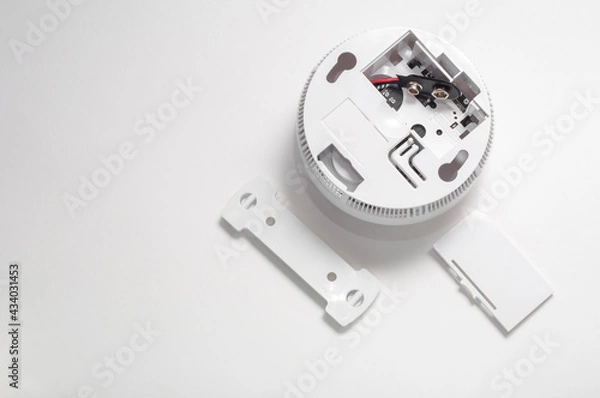Fototapeta Smoke detector on a white background with an open battery compartment