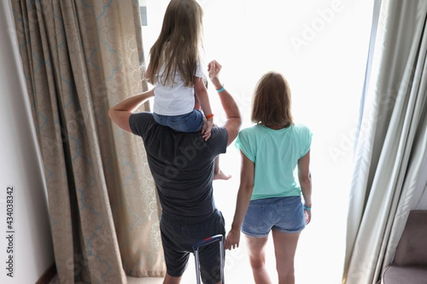 Obraz Parents and child stand in hotel rooms and look out window