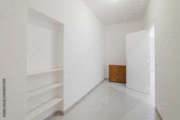 Fototapeta Empty small room with white walls and built-in niche for shelves in an old flat before renovation