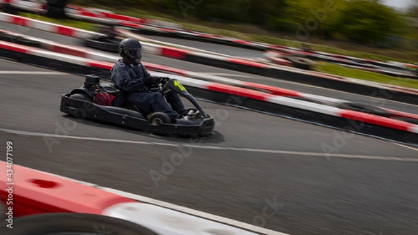 Fototapeta A panning shot of a racing kart as it circuits a track.