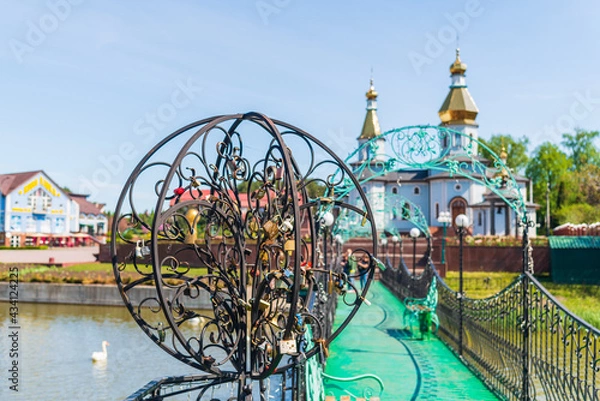 Obraz Bridge with padlocks over the river with a church on the background