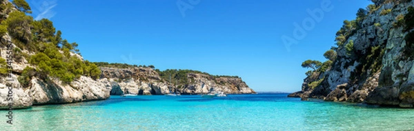 Fototapeta Panoramic view from an empty Cala Macarelleta, with turquoise waters and blue sky, in Menorca, Balearic Islands, Spain