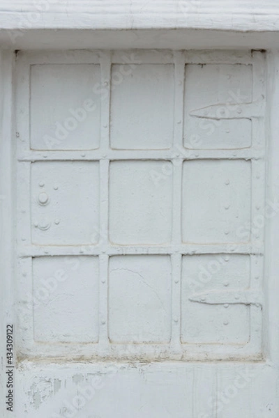 Fototapeta Ancient window shutter in Russian monastery. White painted metal shutter of church window. Russian traditional architecture fragment