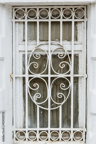 Fototapeta Old monastery window grate. White painted metal window grill of church building. Russian traditional architecture fragment. Kostroma, Golden ring, Russia 