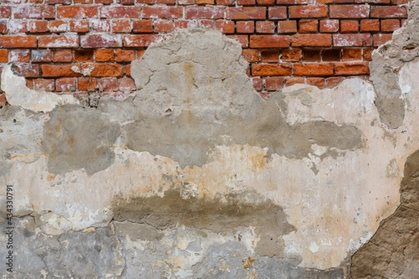 Fototapeta Old red brick wall background with stucco.  Grunge brickwall texture with peeling plaster. Empty abstract stonewall backdrop with paint and plasterwork. Aged flaking painted masonry with copy space