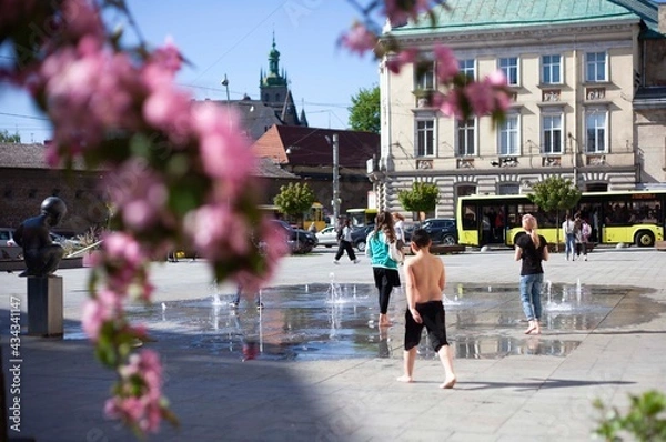Obraz Children bathe in a fountain in the old town square
