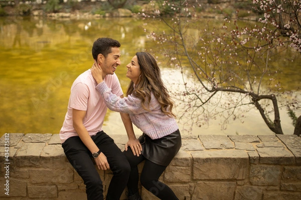 Fototapeta A couple in a romantic moment smiling and hugging in a park