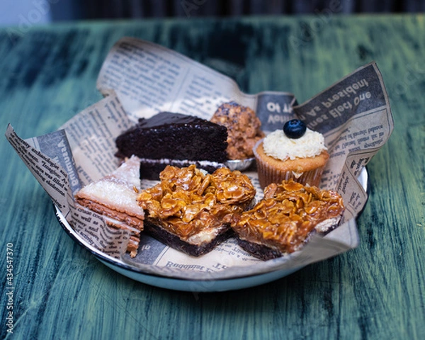 Fototapeta A plate with cupcakes, pecan pie and chocolate cake slices
