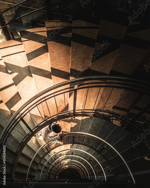 Fototapeta Man walking up the spiral stairs. Path to ascension and inner evolution concept. Fractal geometry. 