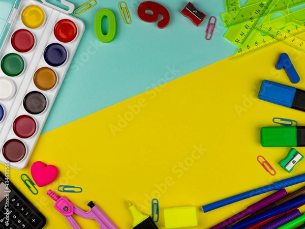 Fototapeta student's desk. Top view of the layout of school items. Rulers, paints, pencils and numbers on a yellow and blue background. Back to school