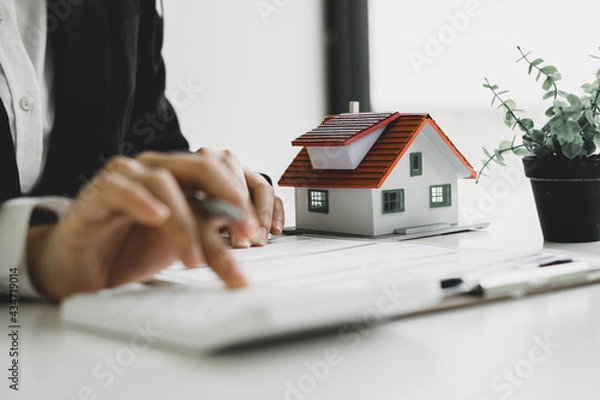 Fototapeta Home agents are using a calculator to calculate the loan period each month for the customer.