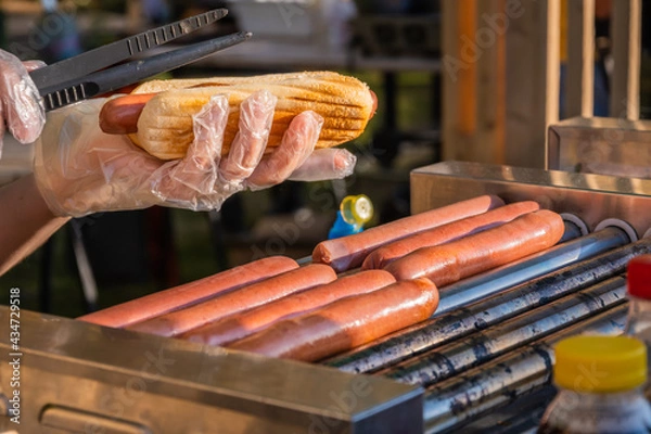 Obraz Sausages are fried on a rotary cooking machine