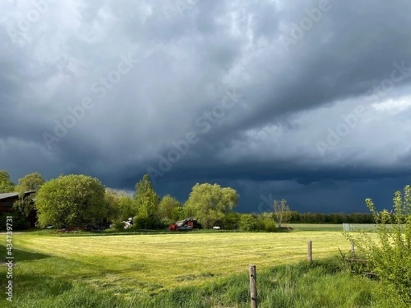 Obraz Schwarze Gewitterwolken über einem hellgrünen Feld