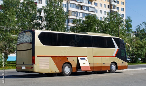 Fototapeta Golden tourist bus close-up on a summer day stands in the parking lot waiting for passengers. blurred focus