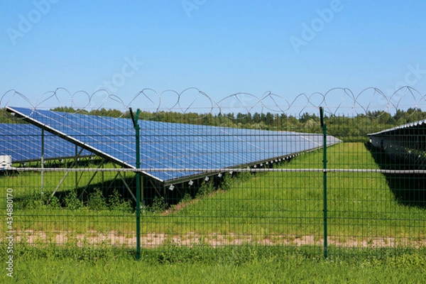Obraz Solar panel on the field behind the barbed wire