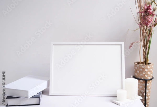 Obraz Mock up white poster frame,candles,book  and beautiful dried flowers in modern wood vase  composition over white wooden table room interior