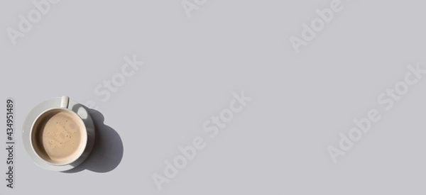 Fototapeta White cup of coffee on gray background with place for text. Minimal concept