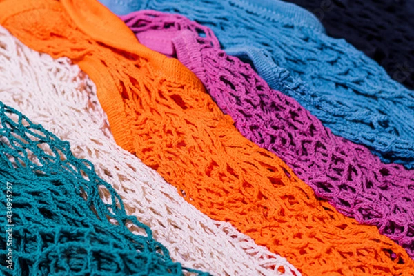 Fototapeta The pattern of multi-colored string bags was shot in macro style. Bright colors for your eco-friendly design.