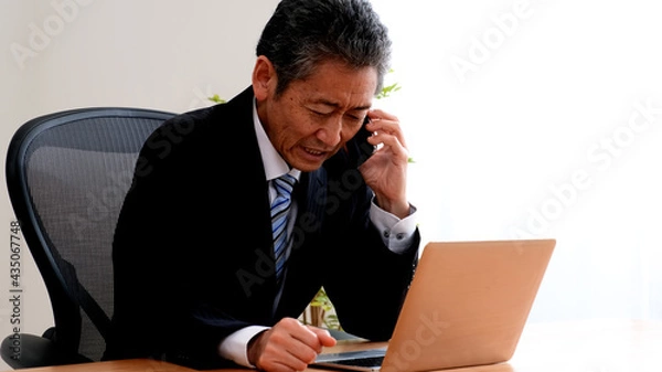 Obraz 電話で取引先に謝罪するシニア社長