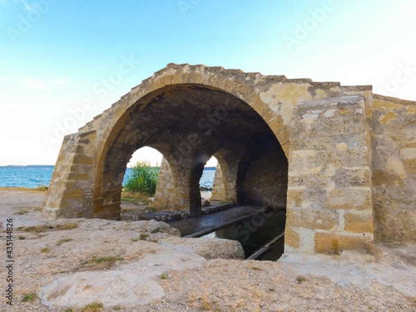 Fototapeta Magnificent old stone wash house from the 18th century called wash house of contagious on the edge of the Berre pond in Saint-Chamas in Provence in France