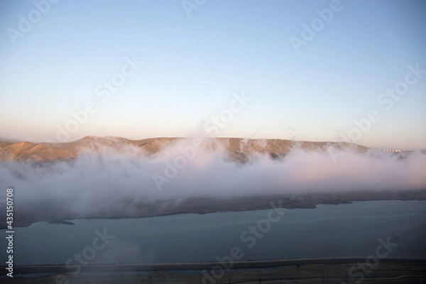 Fototapeta Beautiful clouds flying over the lake near mountains. Evening time shot over the clouds. Baku, Azerbaijan.