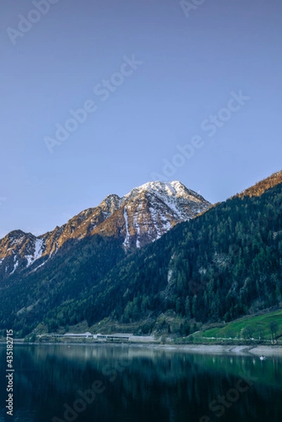 Fototapeta View of the calm waters of the lake of Poschiavo in Switzerland early in the morning
