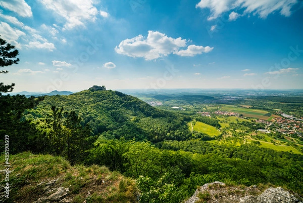 Fototapeta Germany, Hohenneuffen castsle ruins in colorful spring atmosphere on top of a mountain surrounded by endless green nature landscape and villages