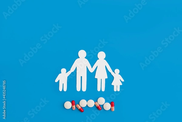 Obraz a paper figure of a family and medical pills on a blue background copy the space. the concept of health preservation, treatment of viral disease and influenza in a pandemic
