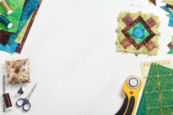 Obraz Patchwork block, stack of fabrics, sewing and quilting accessories. Space for text.