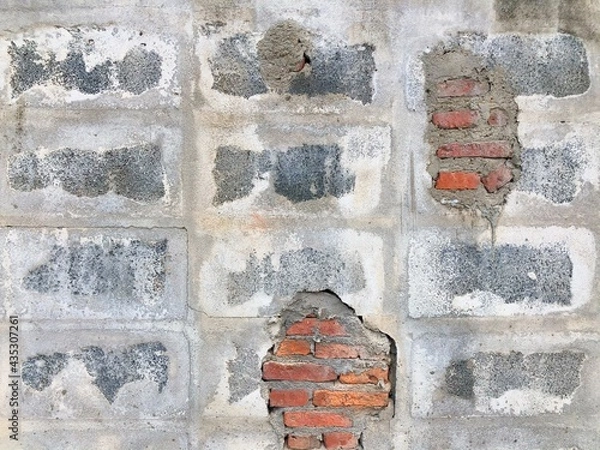 Fototapeta Broken concrete block wall hole was repaired by brick and cement into hole wall. Easy and rare masonry work style of house or building wall.