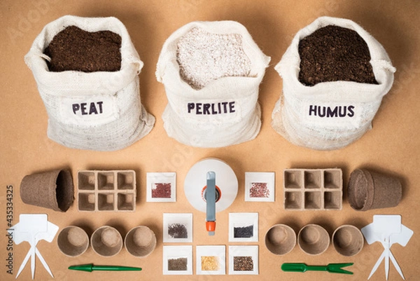 Fototapeta A complete eco-friendly biodegradabale seed starting kit, with peat moss, perlite and worm humus for a potting soil mix, peat trays, pots, an atomizer, plant labels and different seeds.