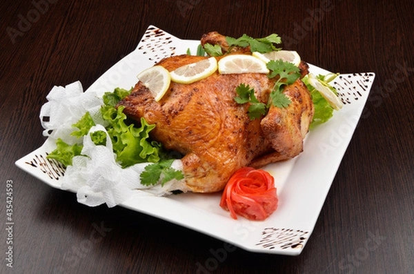 Obraz baked whole chicken with salad and lemon, beautifully served in a white plate