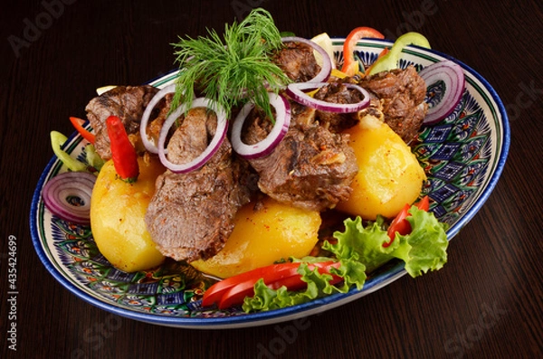 Obraz stew with potatoes, garnish with onion rings, pepper, lettuce and dill, Asian cuisine