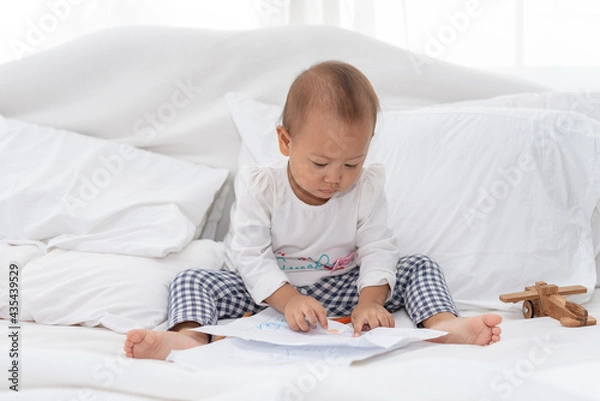 Fototapeta Little toddler child drawing at home, during pandemic Covid-19 quarantine. Happy creative child, homeschooling and home daycare. Weekend leisure activities concept