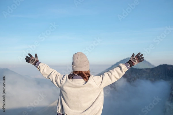 Fototapeta The girl turned her back Spread your arms for freshness and beauty with the view in front of you.