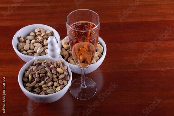Fototapeta Glass of Pink Sparkling Wine with Trio of Nuts