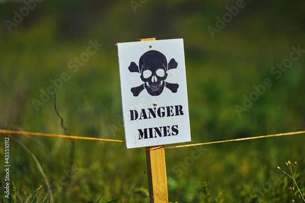 Fototapeta Close-up of a sign with a skull warning of danger in a minefield