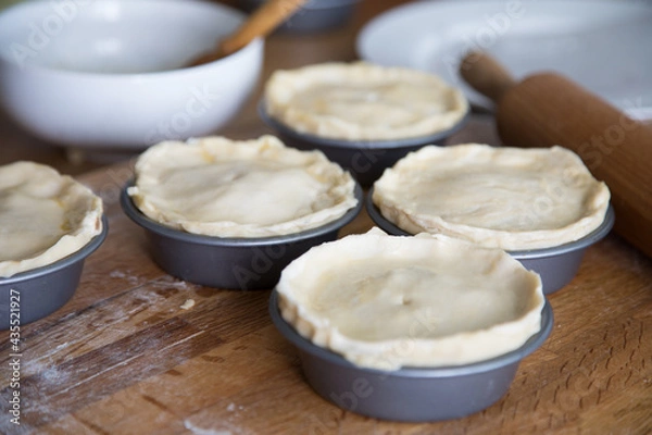 Obraz Preparing meat pies in baking tins with pastry shell 