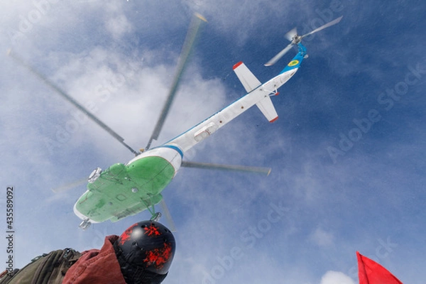 Obraz Helicopter takes off into blue sky with clouds