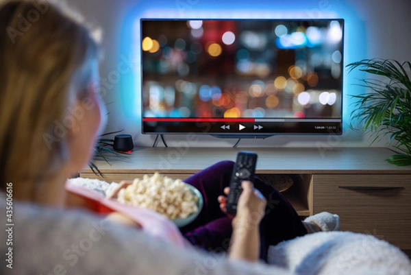 Obraz Woman relaxing at home in evening and watching TV