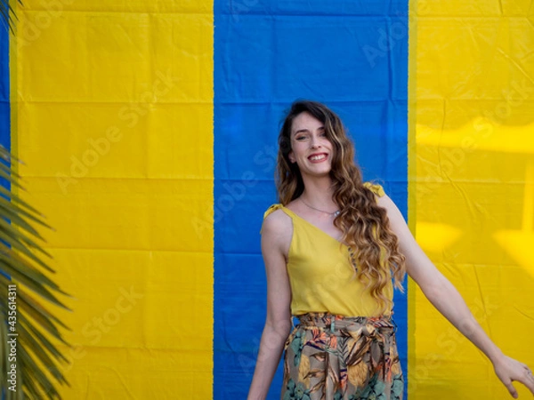 Fototapeta Mujer joven posando sobre un fondo azul y amarillo
